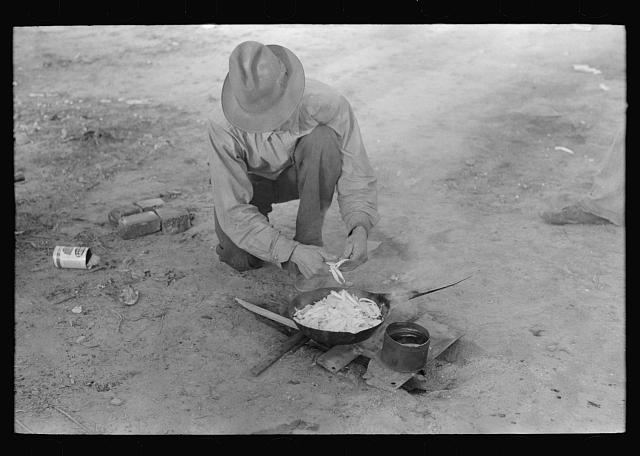 Migrant worker cooking meal over campfire, Edinburg, Texas. 1939